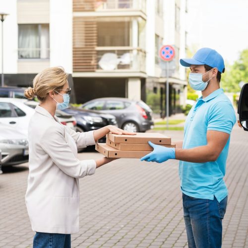 Safe delivery - courier on a van brings a pizza to the client